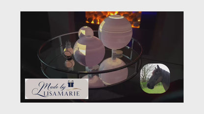 A video featuring three different sized illuminated lithophane globes and a keychain revolving on a table. The Made By LisaMarie logo is displayed in the corner of the video. Soft piano music plays in the background, enhancing the elegant display.